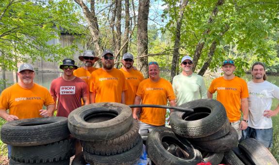 spire volunteers standing in front of tires and debris